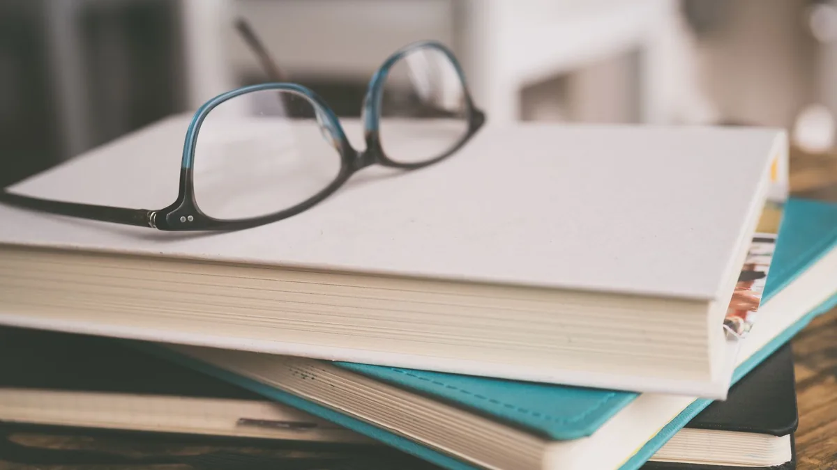 Brille auf einem Stapel Bücher in einer Leseecke